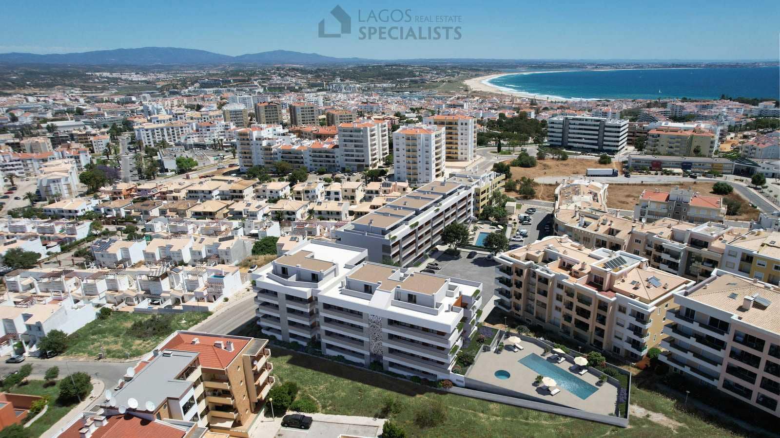 Aerial view of the Domus new-build apartment complex in Lagos with pool and ocean views, near Porto de Mós Beach.