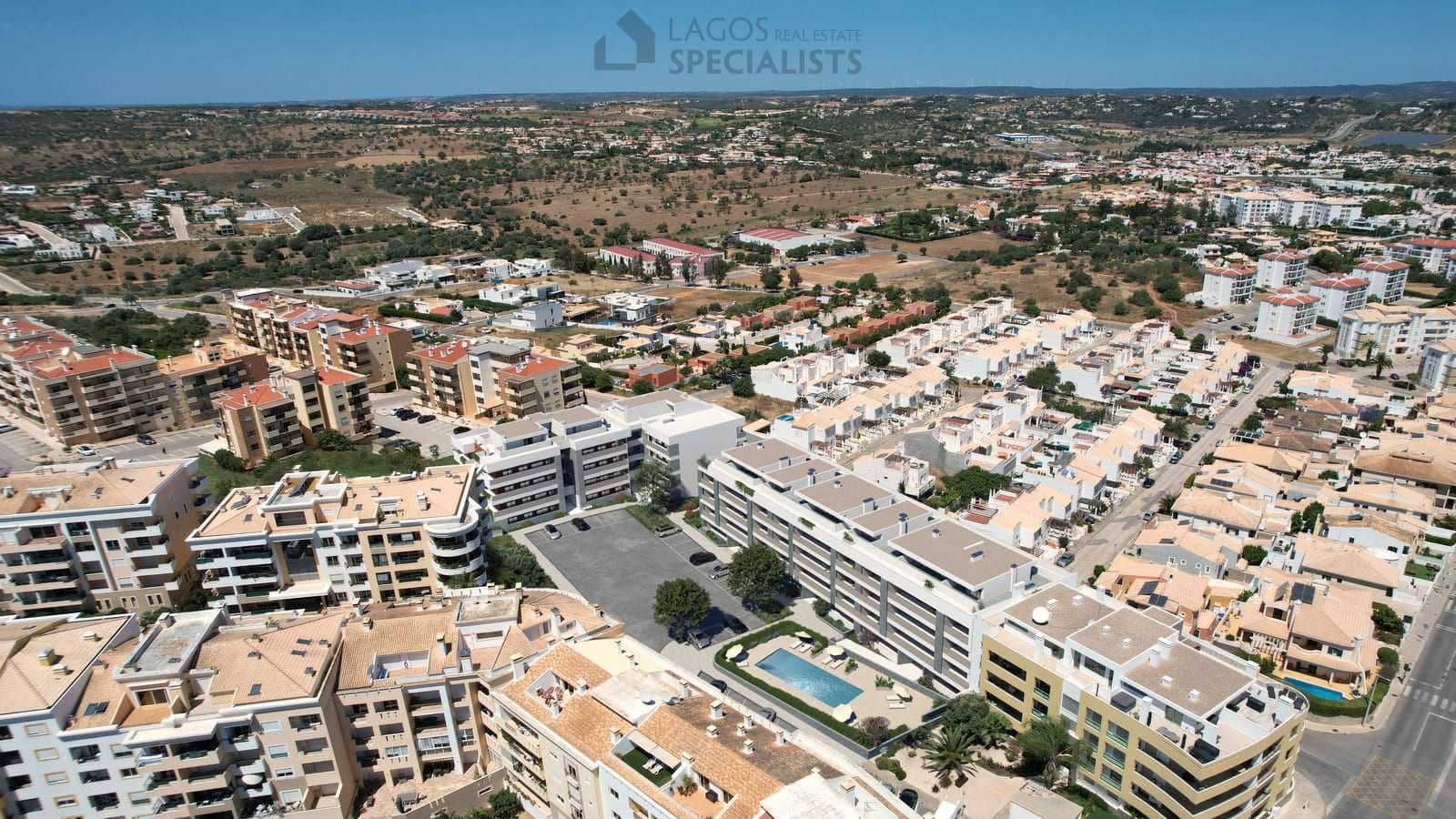 Bird’s-eye view of luxury new-build apartments in Lagos, Algarve, surrounded by calm residential streets and countryside.