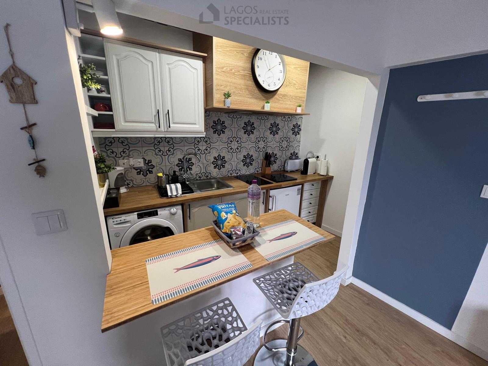 Compact kitchen with breakfast bar and decorative tiles – renovated 1-bed house in Lagos